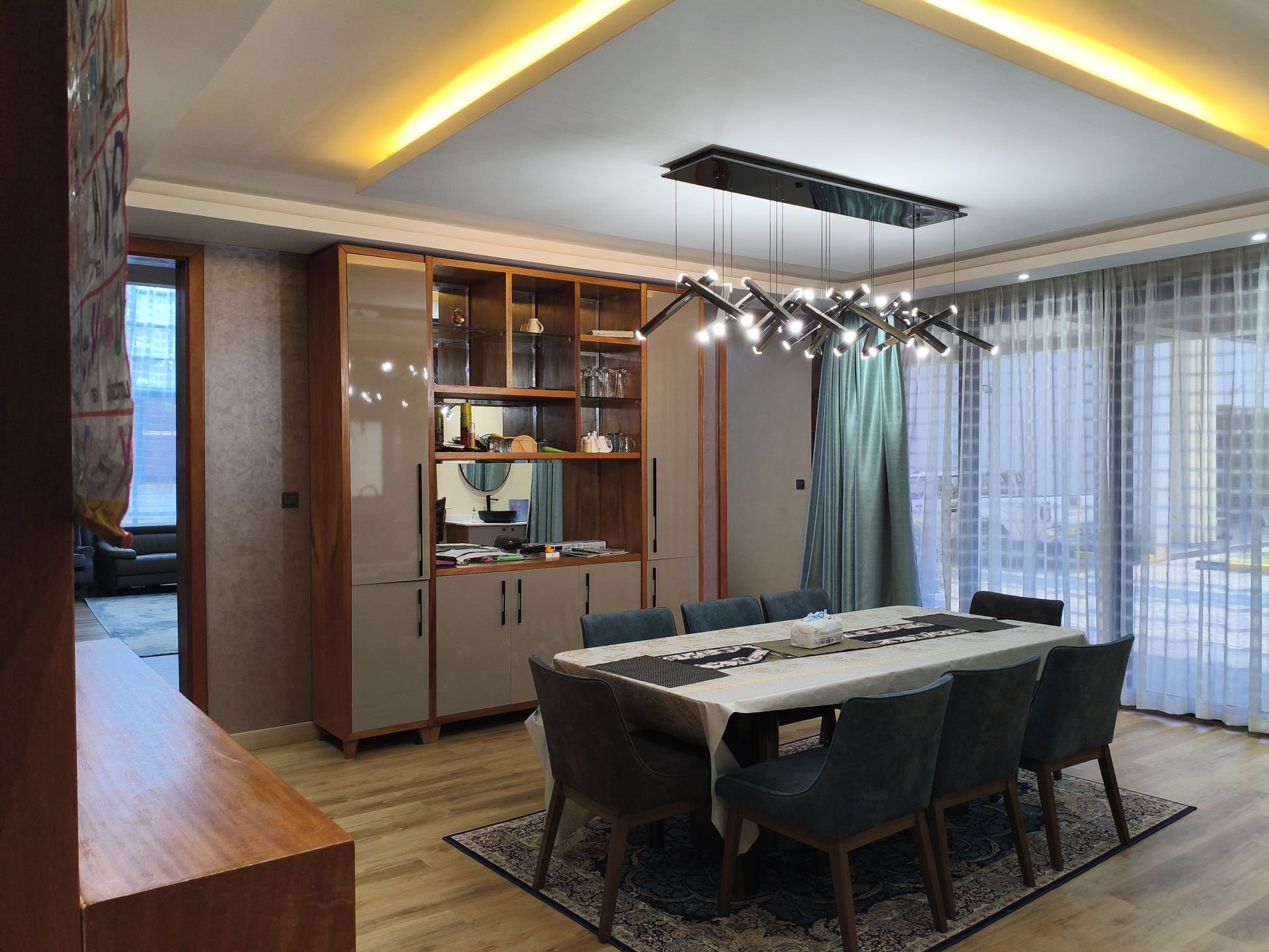 Dining room with sculptural chandelier and custom cabinetry