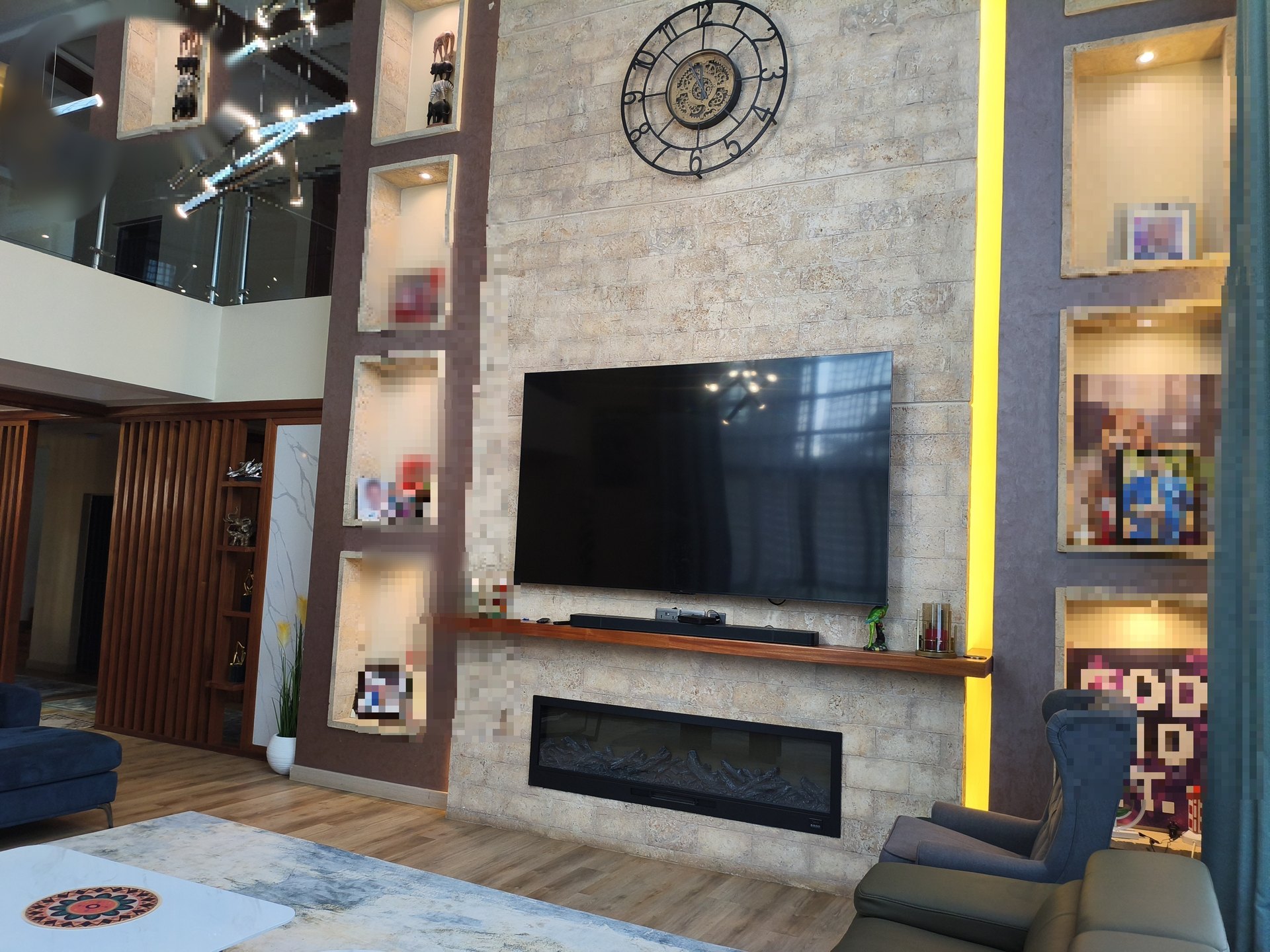 Double-height living room with stone fireplace wall and niches